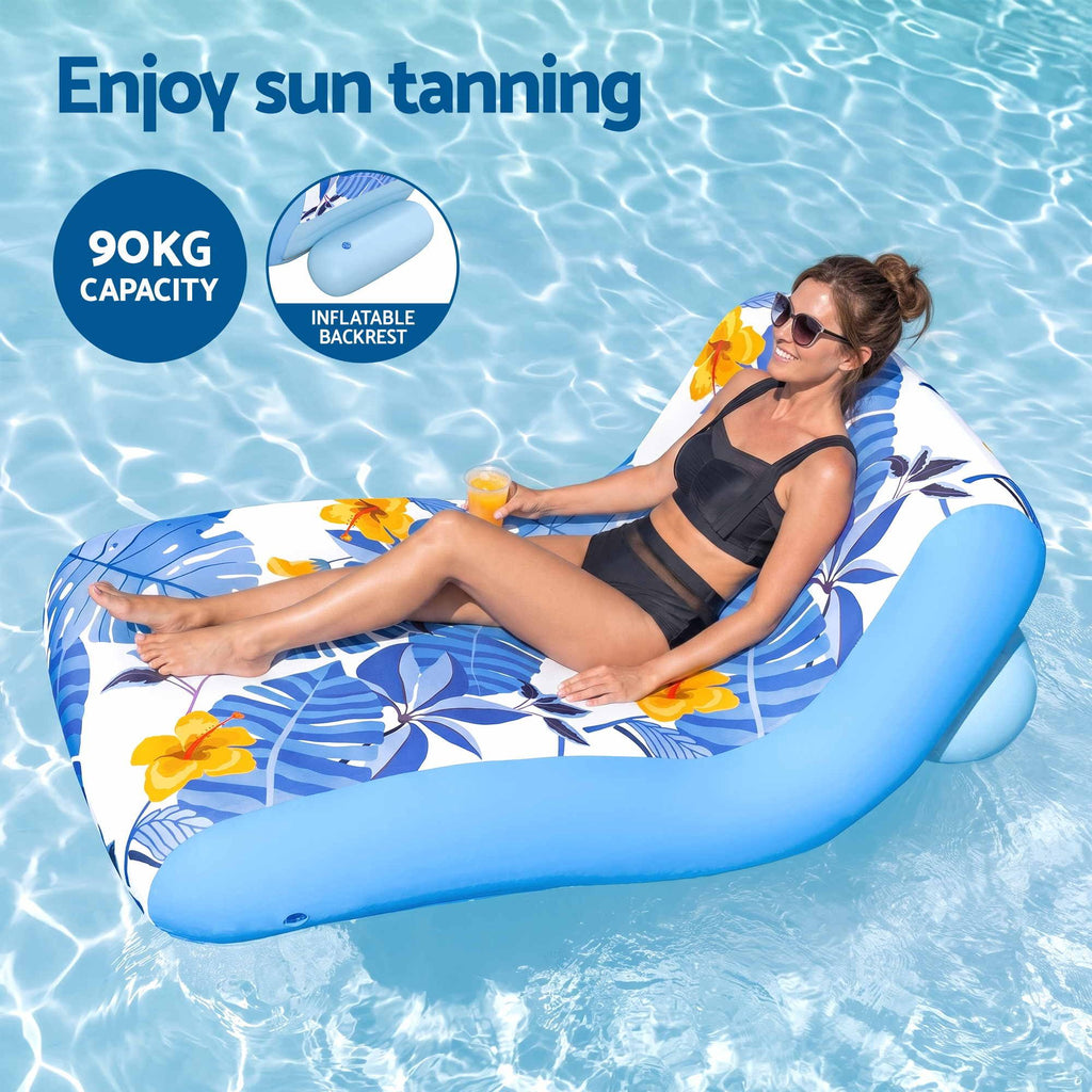 A woman reclining on a blue and white tropical floral inflatable pool float in a swimming pool, with text overlays reading 'Enjoy sun tanning', '90KG CAPACITY', and 'INFLATABLE BACKREST'.