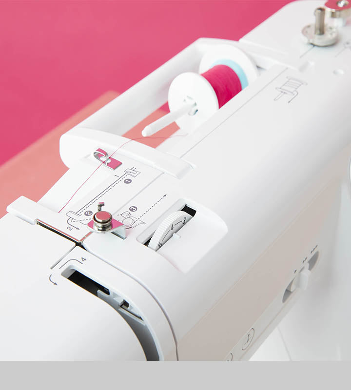 Close-up of a sewing machine on a pink and white background

Details