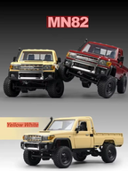 Three RC truck pickup models shown on a dark-to-light gradient background: two lifted trucks at the top (one yellow, one red) and one tan truck at the bottom labeled 'Yellow White'. Large text reads 'MN82'.