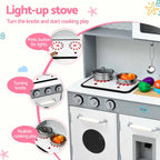 A children's toy play kitchen stove set against a white background with feature callout graphics. The toy stove is white and gray with silver knobs, a black stovetop, and a black cooktop mat with red splatter details.