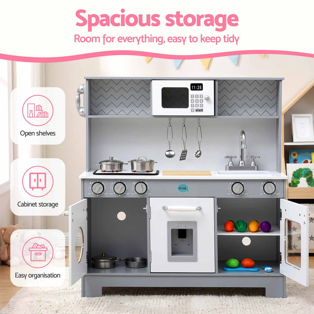 A children's toy kitchen playset with gray cabinets, white countertops, a built-in microwave, stove, sink, and colorful balls in the lower shelves. The image includes marketing text and icons highlighting open shelves, cabinet storage, and easy organization.

Details