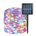 Multicolor solar string lights with a coiled wire and star-shaped LEDs, shown next to a black rectangular solar panel on a stake, on a white background.