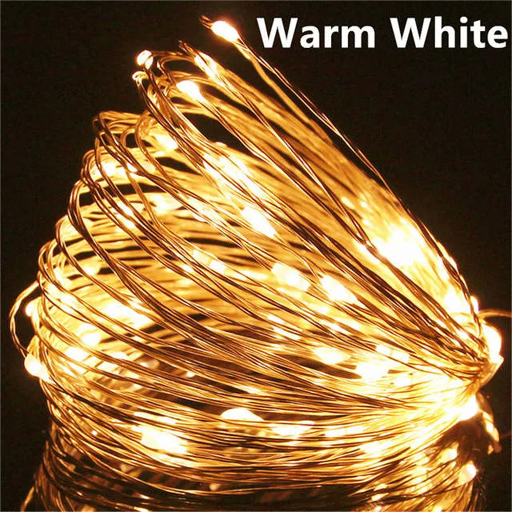 Coiled string of warm white LED lights on a dark background

