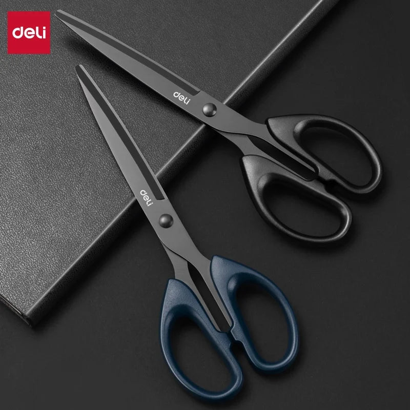 Two pairs of Deli scissors on a dark surface with Deli branding.