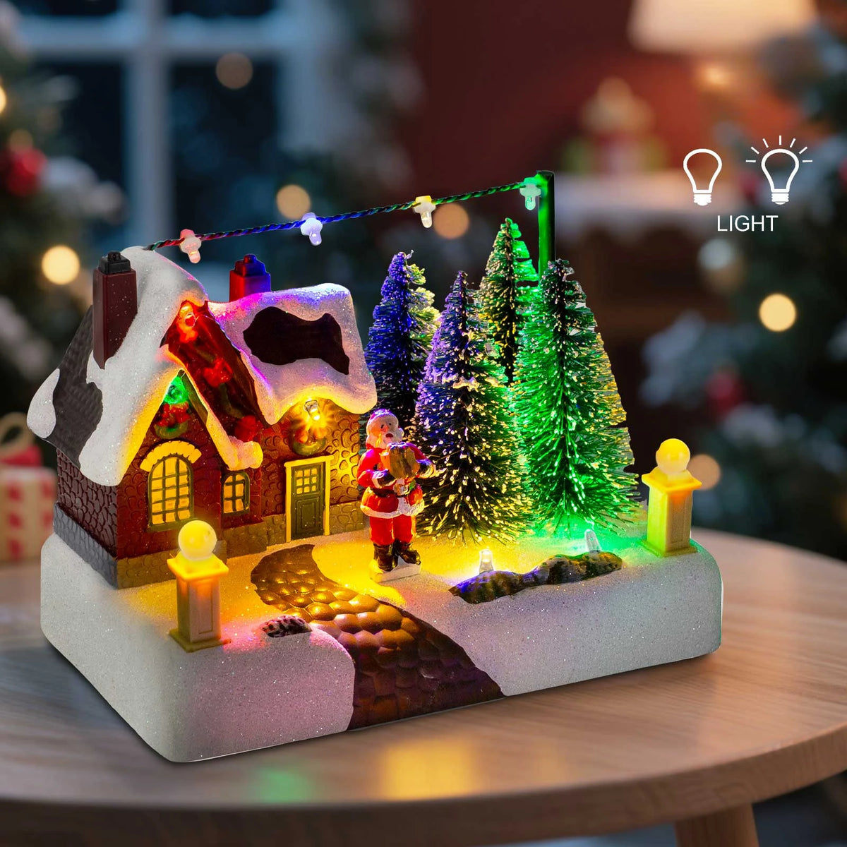 Christmas-themed miniature village scene with lights on a table.