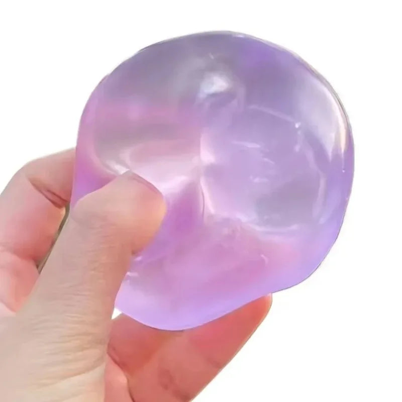 A hand holding a translucent purple and lavender gel-like stress toy against a plain white background.