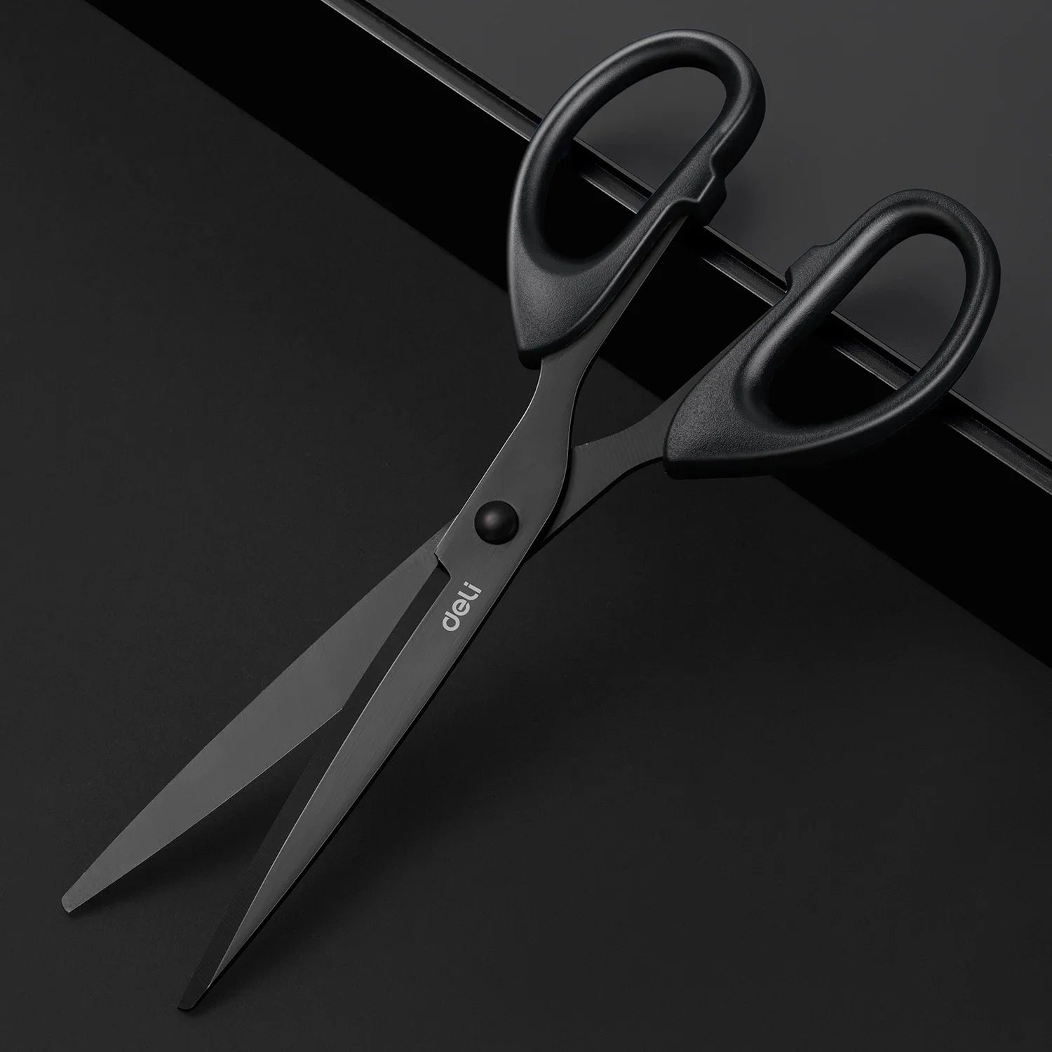 Black scissors with 'deli' branding on a black background