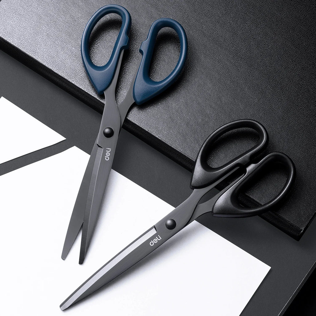 Two pairs of Deli scissors on a black and white surface