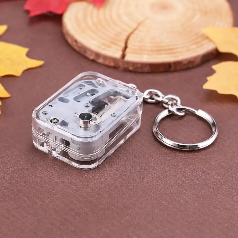 Clear cassette tape keychain on a brown surface with autumn leaves