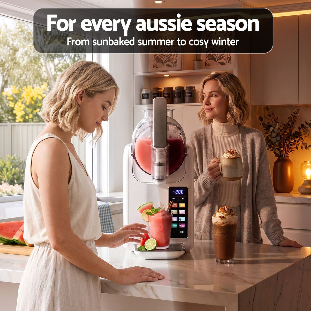 A countertop beverage preparation machine is shown in a bright kitchen with two women standing beside it, one adding ingredients and one holding a drink. A black text banner at the top reads, 'For every aussie season From sunbaked summer to cosy winter.