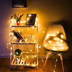 Decorative string lights on a shelf and chair in a cozy room.