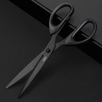 Black scissors with 'deli' branding on a dark background