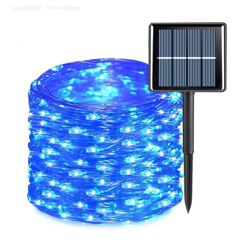 A roll of solar garden string lights glowing bright blue, shown next to a small black solar panel stake on a white background.