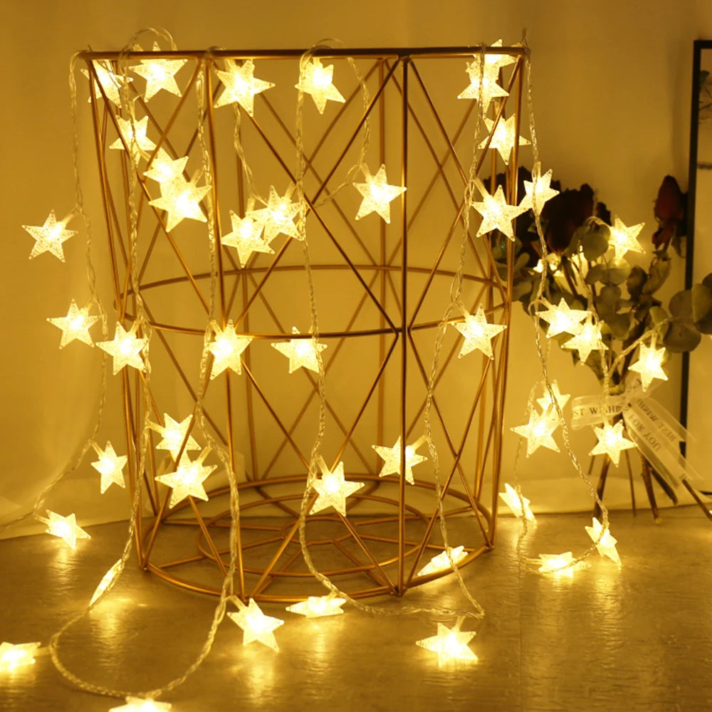 Star-shaped string lights draped over a geometric metal frame with a warm glow.