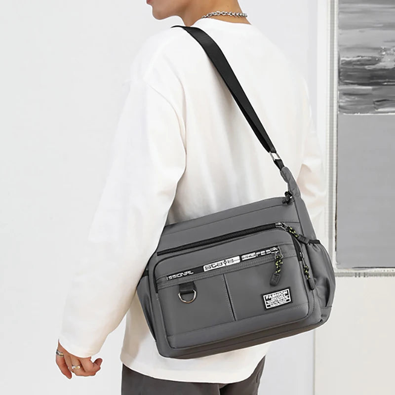 Person wearing a gray crossbody bag with a white background