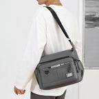 Person wearing a gray crossbody bag with a white background