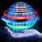 A glowing spherical grid toy floating above an open hand against a starry dark background. The sphere emits bright blue, red, green, and orange light trails, with a small miniature house visible inside the cage-like structure.