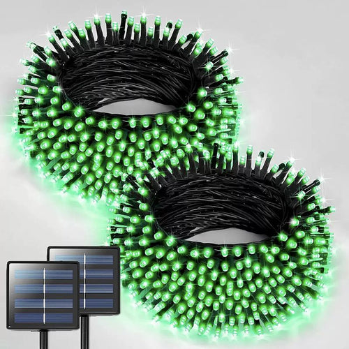 Two coiled bundles of solar string lights with bright green illuminated LEDs and black wiring, shown on a light gray background with two small solar panels pictured in the lower left corn