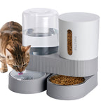 Pet feeding station with water and food bowls, featuring a cat drinking from the water bowl.