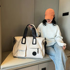 Person sitting with a beige bag on a bench indoors