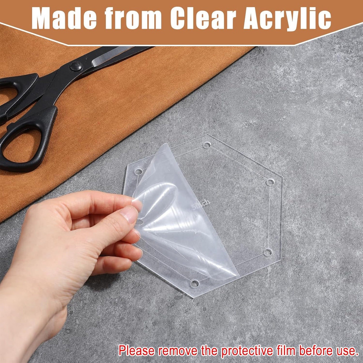 Clear acrylic sheet held by a hand with scissors and wooden board in the background