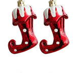 Two red glass boot ornaments with white snow-like tops on a white background