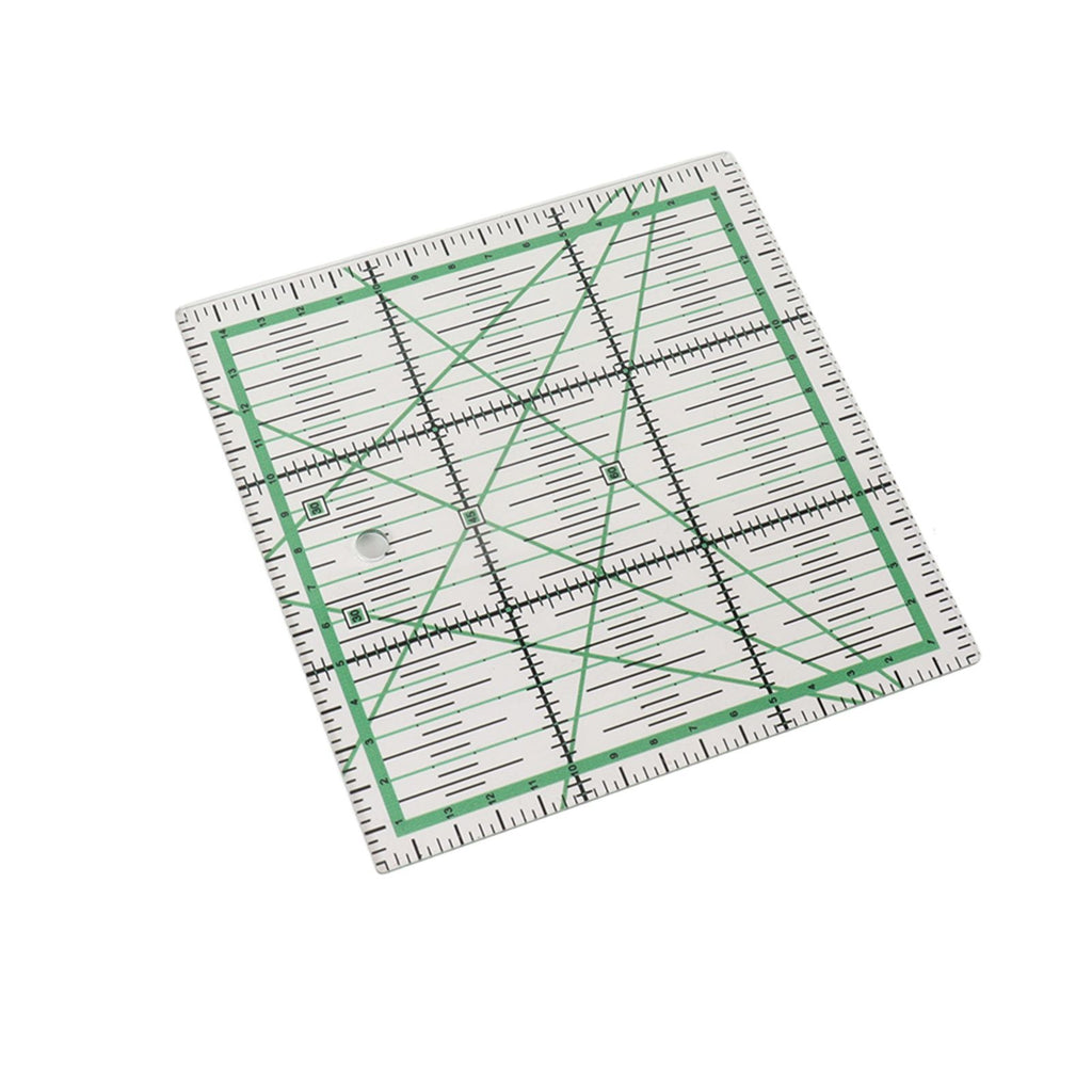 A square quilting ruler with green grid lines and black measurement markings, shown at an angle on a plain white background.