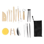 A clay sculpting tool set laid out on a white background, including wooden sculpting knives, metal loops, a carving tool, two pointed sticks, a yellow sponge, a small wooden stand, a metal spatula, and a black zip pouch.