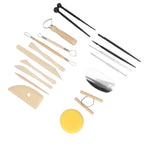 A 16-piece clay sculpting tool set arranged on a plain white background. The set includes wooden spatulas, metal loops, tweezers, a metal scraper, a yellow sponge, and two black ball pens.