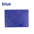 A blue cutting mat with white grid lines, angle guides, and a small set of circular and rectangular sample shapes in the bottom right corner, shown on a white background with the word 'blue' in the top left.
