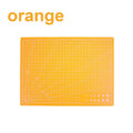 An orange cutting mat with a white grid and diagonal guide lines, shown on a white background with the word 'orange' in the top left corner.
