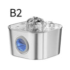 A stainless steel pet water fountain with a clear water spout and a blue gem-like accent on the front, shown on a white background with the text 'B2' in the upper left.