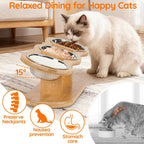 A cat elevated double bowl feeder with two stainless steel bowls on a wooden stand, shown with a cream-colored cat eating in a home setting. The image includes text overlays highlighting features such as 15-degree elevation, joint preservation, nausea prevention, and stomach care.