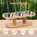 Wooden pet feeder with three stainless steel bowls on a wooden surface, bamboo background.