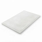 A rectangular white marble cutting board with a raised border, shown at an angle on a seamless white background.