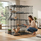 A woman crouches beside a large black multi-level cat playpen in a bright living room, with several cats inside the enclosure and a hammock, bed, and climbing elements visible.

Details