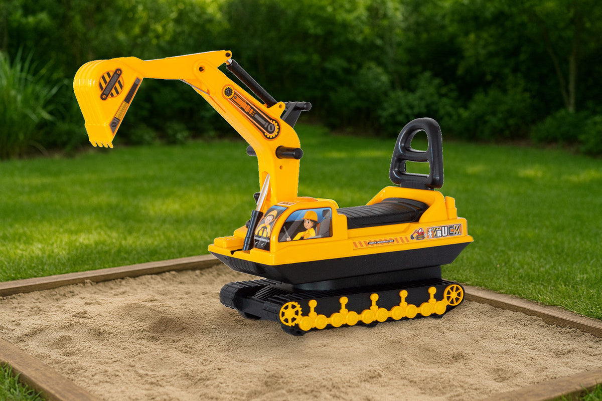 Toy excavator on a sandbox with grass in the background