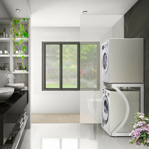 Modern laundry room with stacked washer and dryer units, window, and shelves.