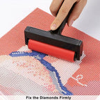 Person using a red roller to fix diamonds on a cross-stitch project
