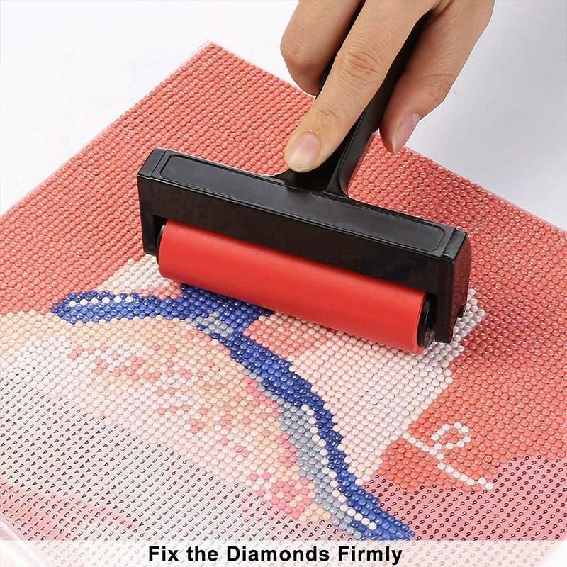 Person using a red roller to fix diamonds on a cross-stitch project