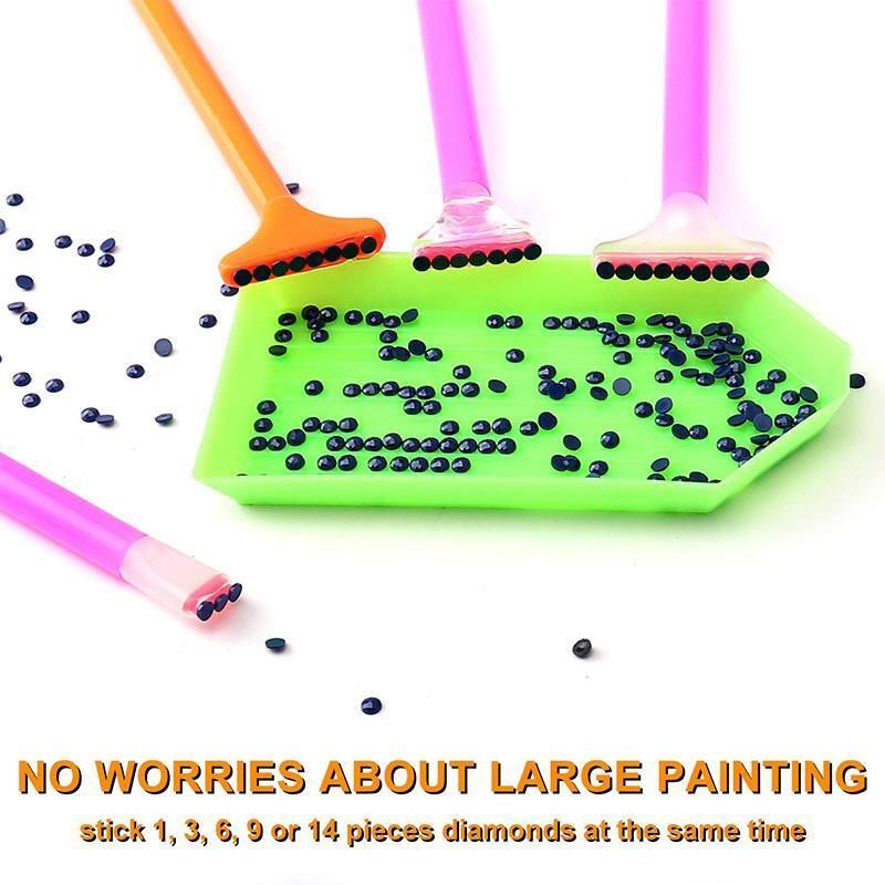 A set of diamond painting sticks with bright pink and orange handles, featuring clear heads with black spherical tips, shown on a white background with loose black beads and a green tray holding some of the beads. Text at the bottom reads 'NO WORRIES ABOUT LARGE PAINTING' and 'stick 1, 3, 9 or 14 pieces diamonds at the same time'