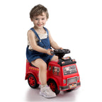 Child sitting on a red toy fire truck with a white background