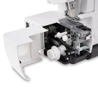 Close-up of a white and black sewing machine with built in overlocker showing internal mechanical components, a white dial, and a white protective cover swung open on a white background.