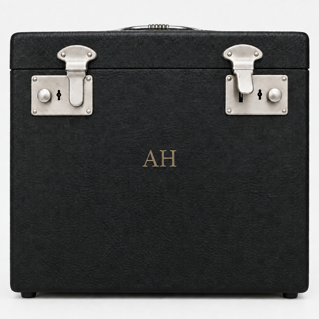This  black textured hard case with silver metal latches and a gold monogram  comes withis preloved Singer 222k1 feather weight sewing machine. photographed against a light gray background.